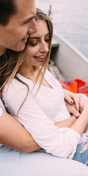 handsome-guy-beautiful-girl-resting-boat-lake-min